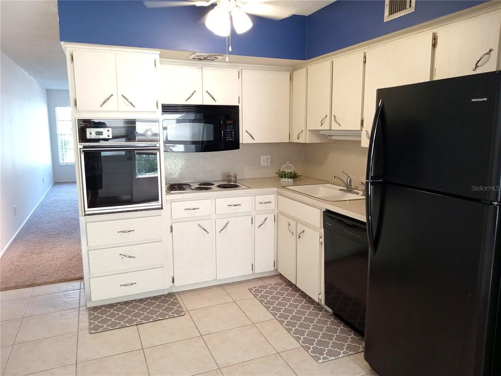 2427 Rhodesian Drive, Unit 11 Clearwater, FL 33763 - Photo 7 of 44 a kitchen with a stove a sink and a refrigerator