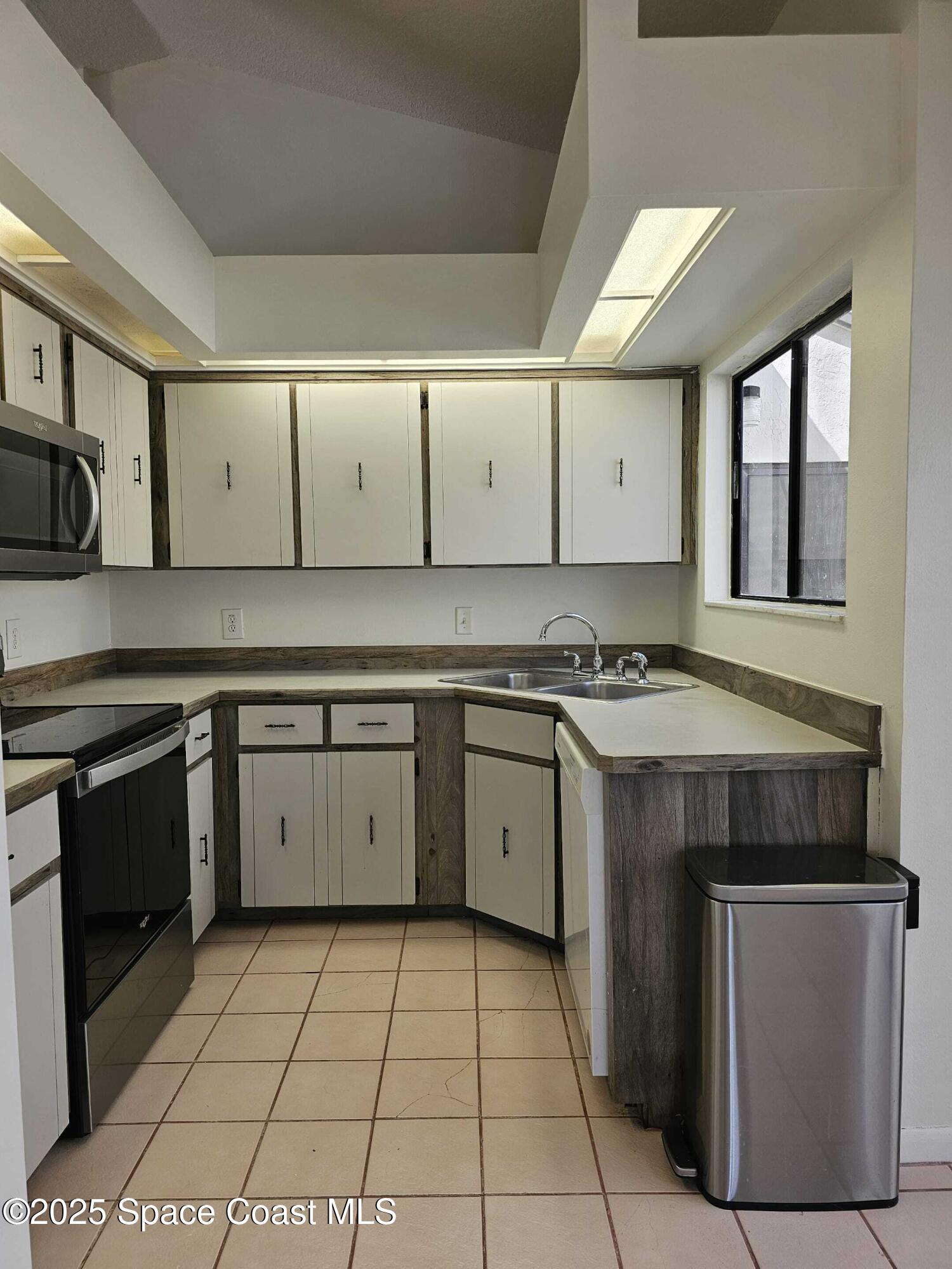 391 Cypress Point Drive Melbourne, FL 32940 - Photo 13 of 28 a kitchen with a stove sink and cabinets