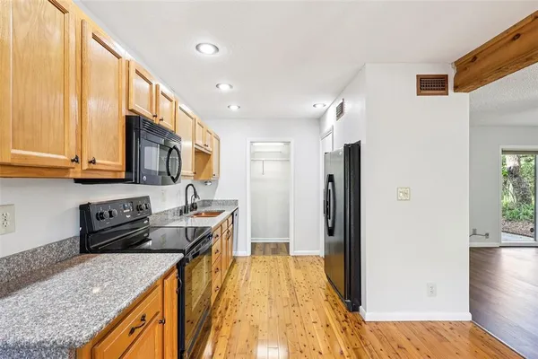 a kitchen that has a sink a refrigerator and a stove top oven