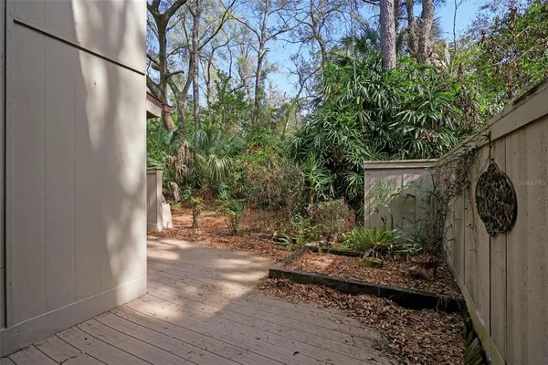 a view of a big yard with plants and large trees