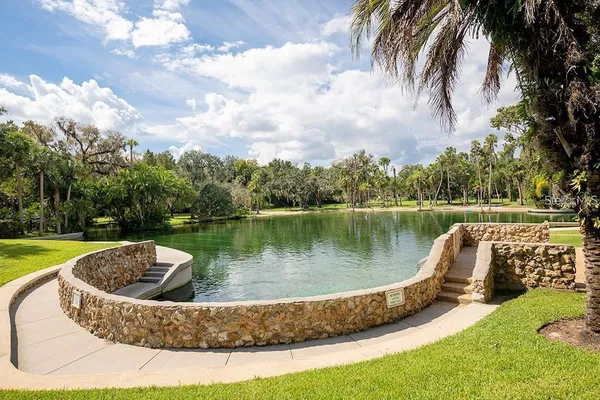 a view of a house with a small yard and large trees