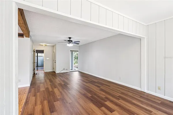 a view of an empty room with kitchen and a window