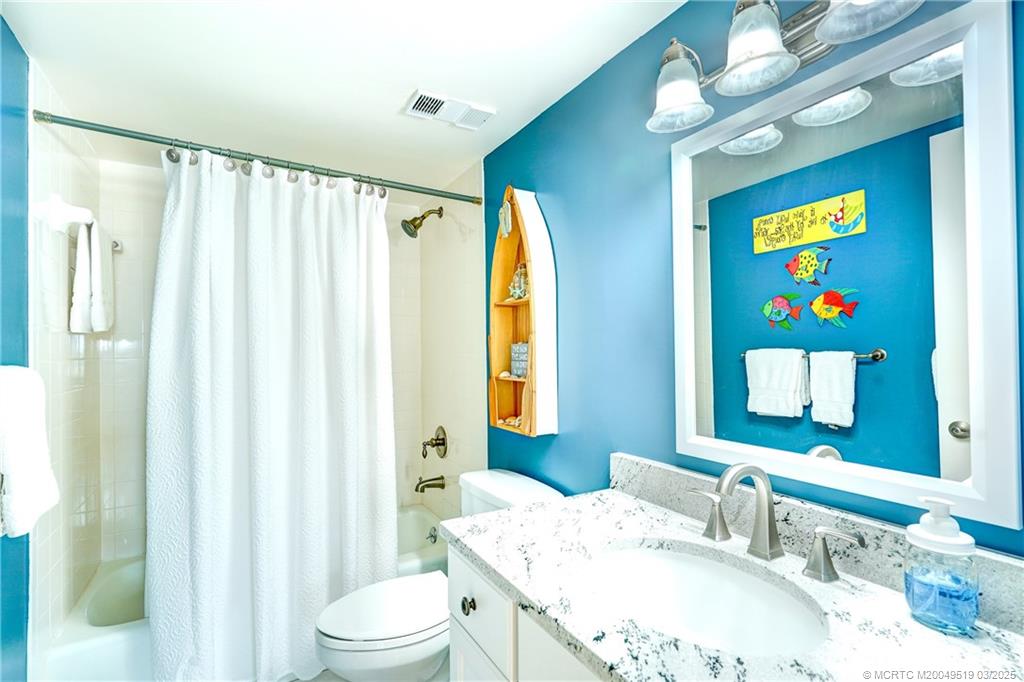 40 Northeast Plantation Road, Unit 311 Stuart, FL 34996 - Photo 18 of 19 a bathroom with a sink a toilet and a mirror