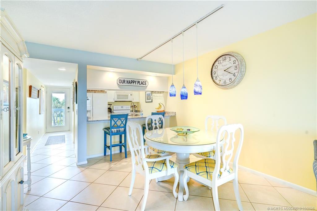 40 Northeast Plantation Road, Unit 311 Stuart, FL 34996 - Photo 9 of 19 a dining room with furniture and a clock