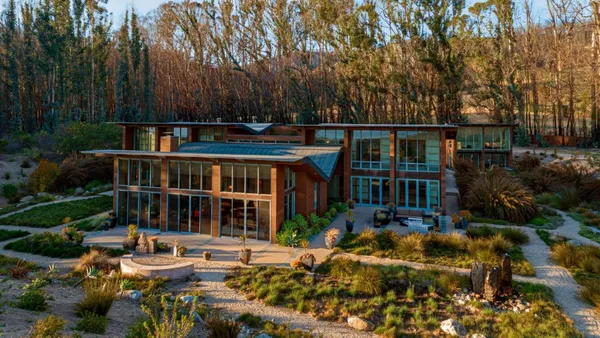 a front view of a house with a yard and lake view