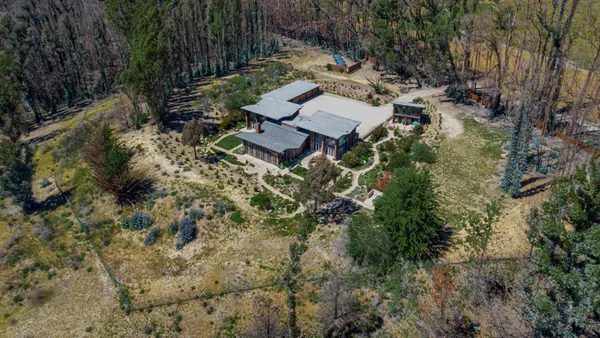 a front view of a house with a yard and potted plants