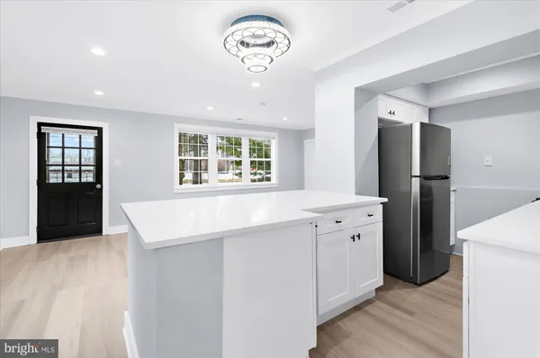 a kitchen with a refrigerator a sink and dishwasher with wooden floor