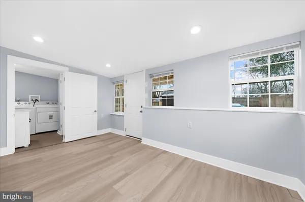 a view of empty room with wooden floor and a window