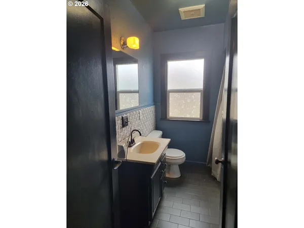 a bathroom with a shower curtain and a window