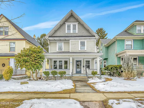a front view of a house with garden and seating