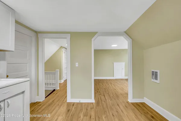 a view of a hallway with wooden floor and staircase