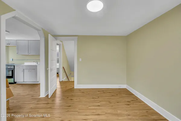 a view of empty room with wooden floor