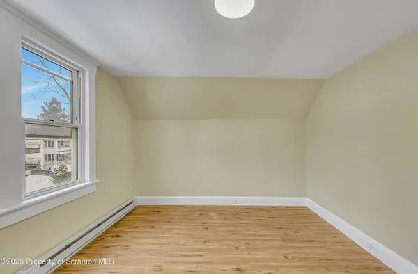 a view of a room with wooden floor and window
