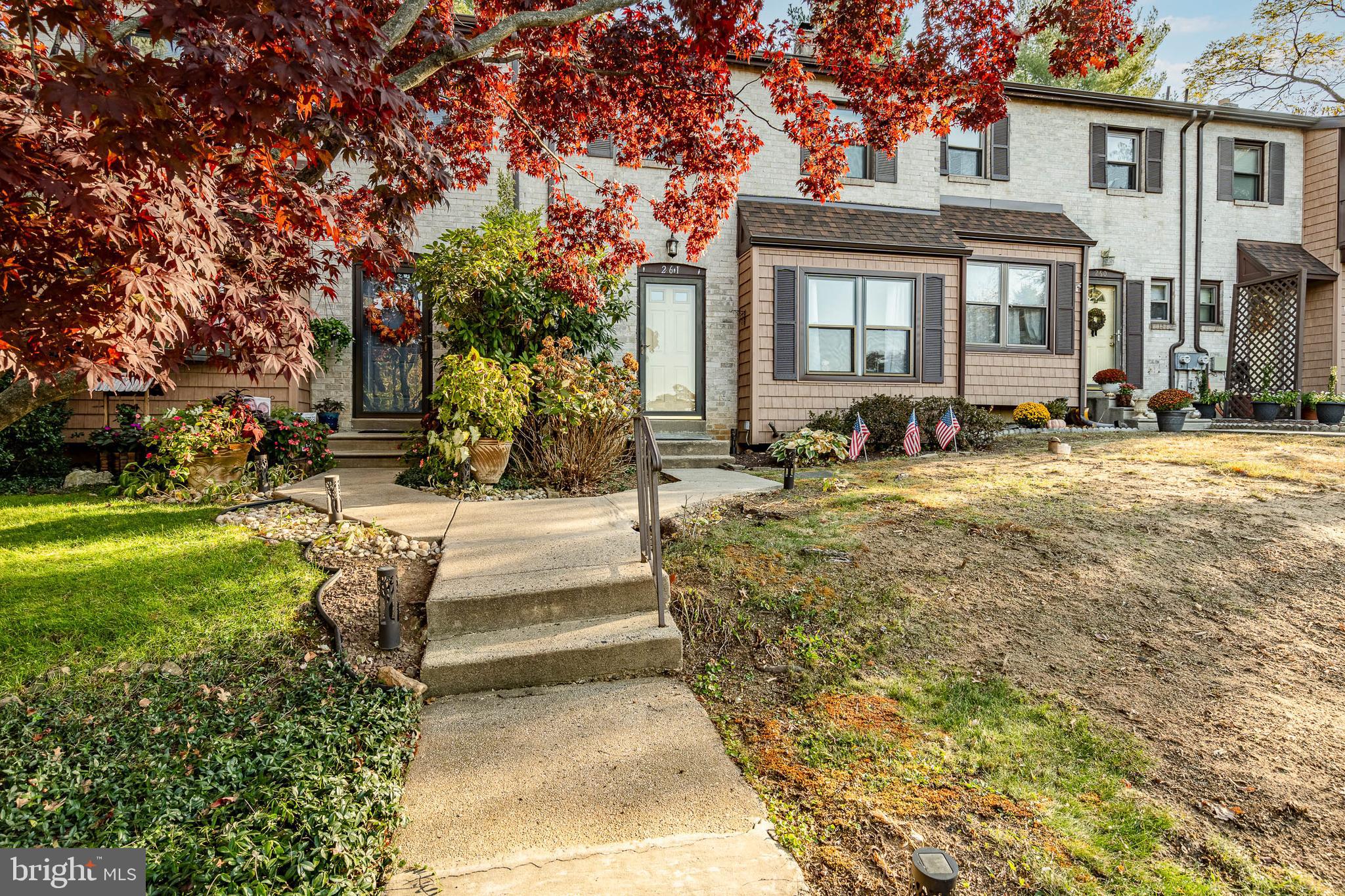 261 Bishop Drive Aston, PA 19014 - Photo 5 of 36 a view of a brick house with a yard patio and fire pit