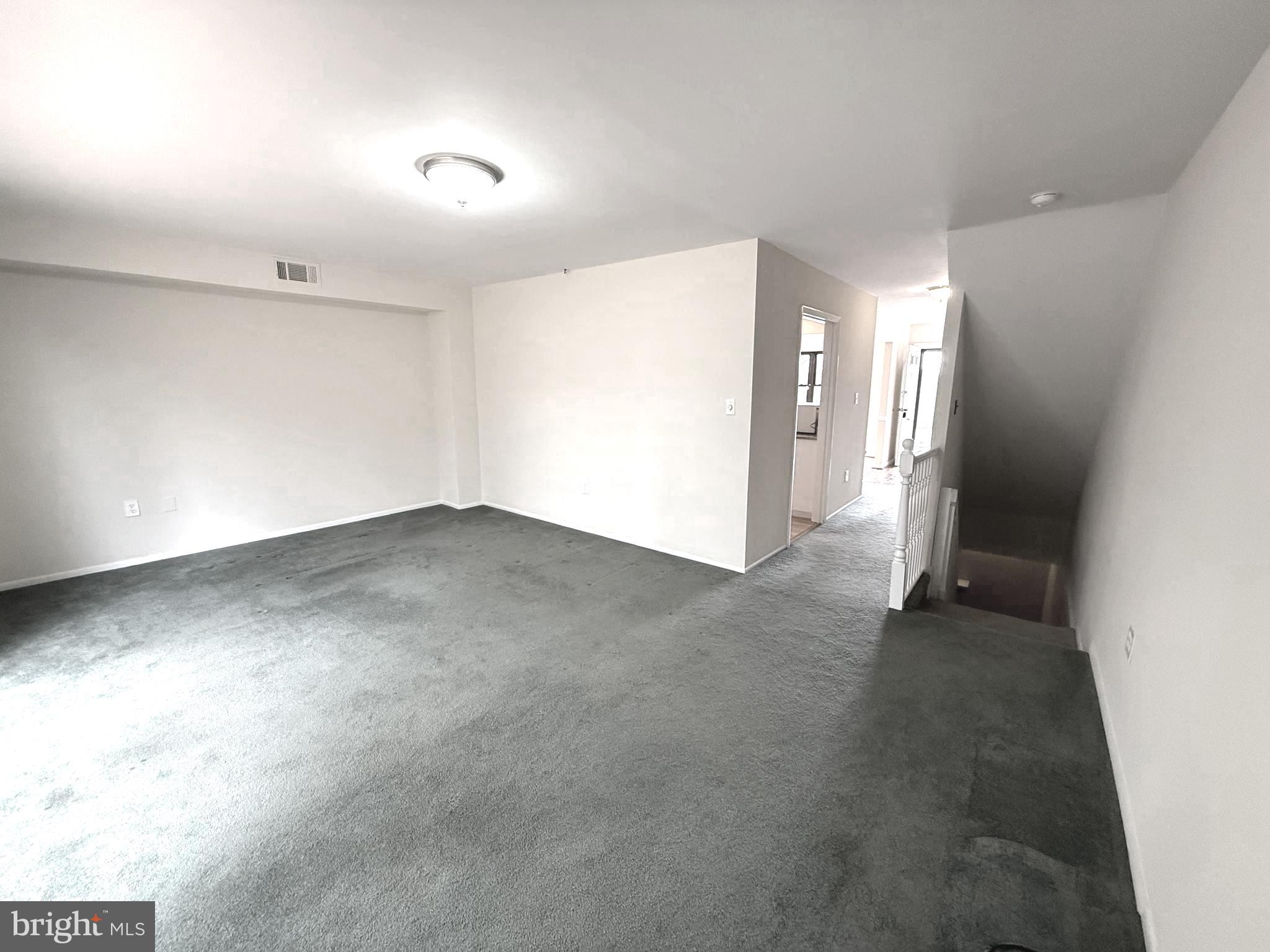 261 Bishop Drive Aston, PA 19014 - Photo 9 of 36 an empty room with staircase and mirror