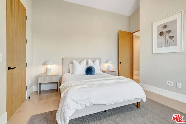 a large bed sitting in a bedroom next to a window