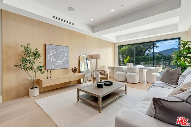 a living room with patio furniture and a wooden floor
