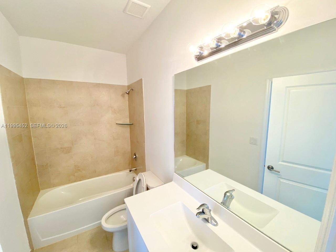 24920 Southwest 112th Court Homestead, FL 33032 - Photo 25 of 48 a bathroom with a bathtub shower sink vanity mirror and toilet