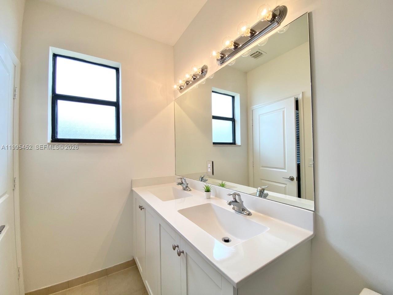 24920 Southwest 112th Court Homestead, FL 33032 - Photo 26 of 48 a bathroom with 2 sink and a mirror