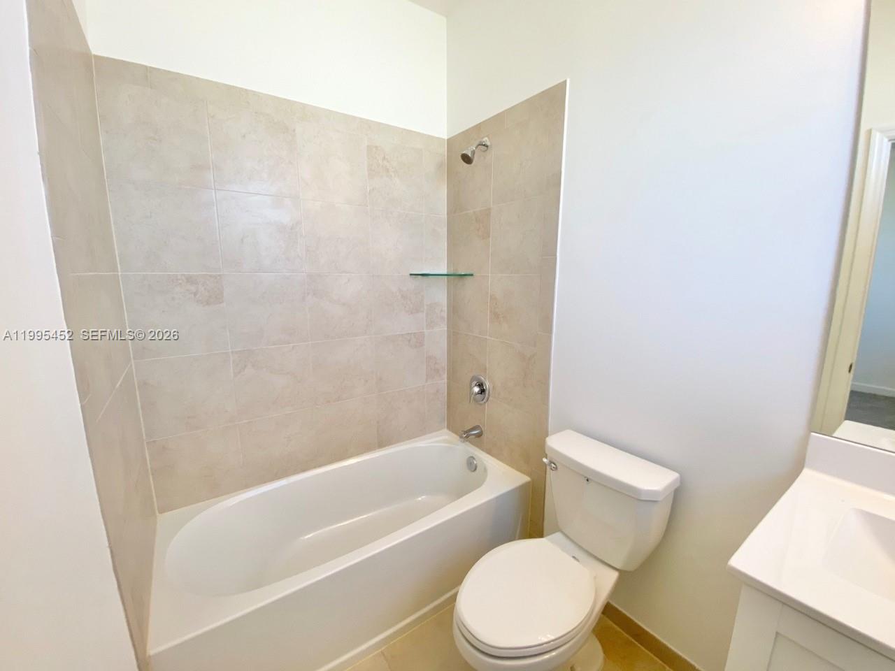 24920 Southwest 112th Court Homestead, FL 33032 - Photo 29 of 48 a white toilet and tub sitting next to a bathroom sink