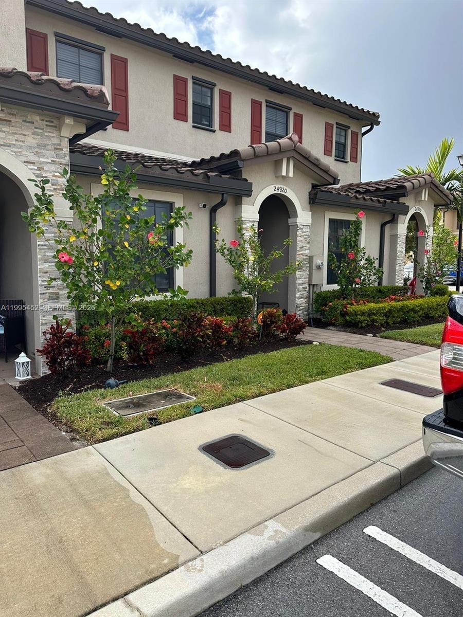 24920 Southwest 112th Court Homestead, FL 33032 - Photo 38 of 48 a front view of a house with a yard and potted plants