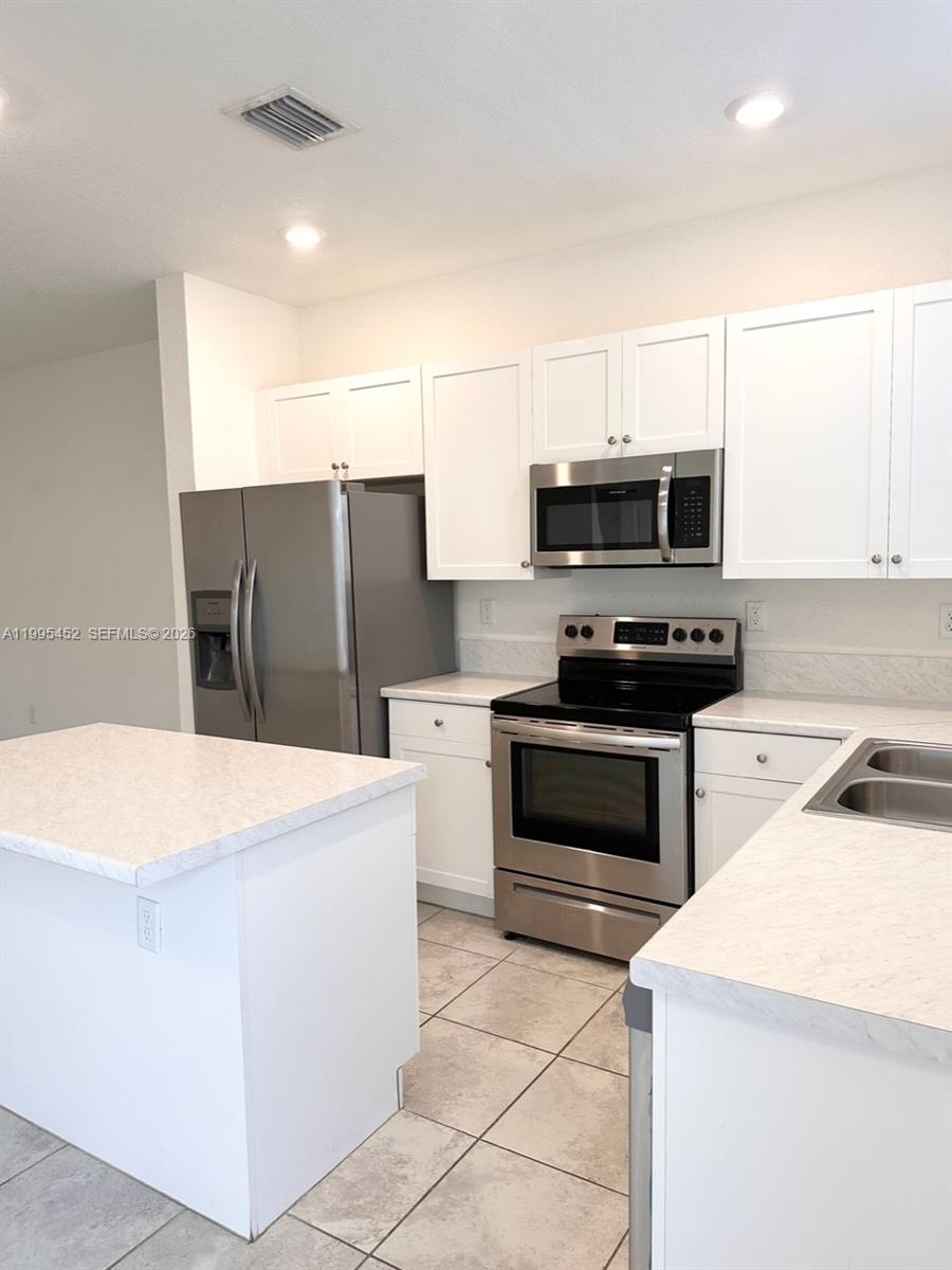 24920 Southwest 112th Court Homestead, FL 33032 - Photo 4 of 48 a kitchen with a cabinets and steel appliances