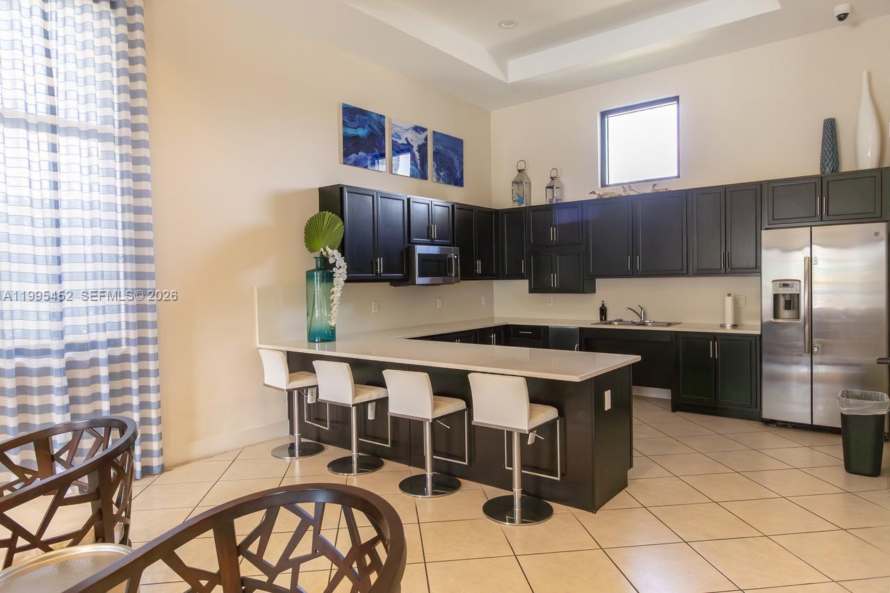 24920 Southwest 112th Court Homestead, FL 33032 - Photo 43 of 48 a kitchen with stainless steel appliances a stove a sink cabinets and a refrigerator