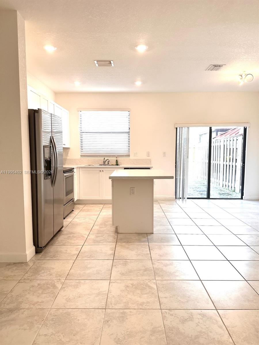 24920 Southwest 112th Court Homestead, FL 33032 - Photo 8 of 48 a kitchen with a stove a sink dishwasher and a refrigerator
