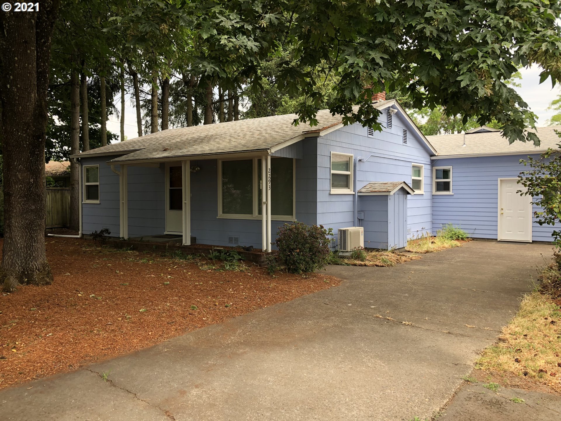 a view of a house with a yard and large tree