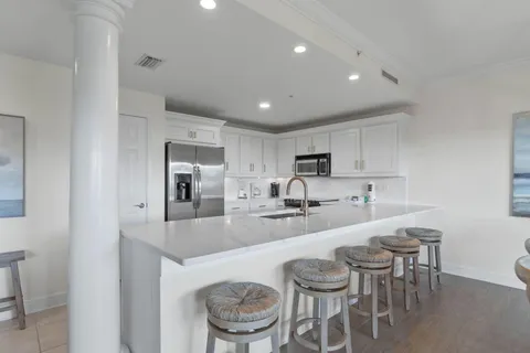 a kitchen with sink a microwave and chairs