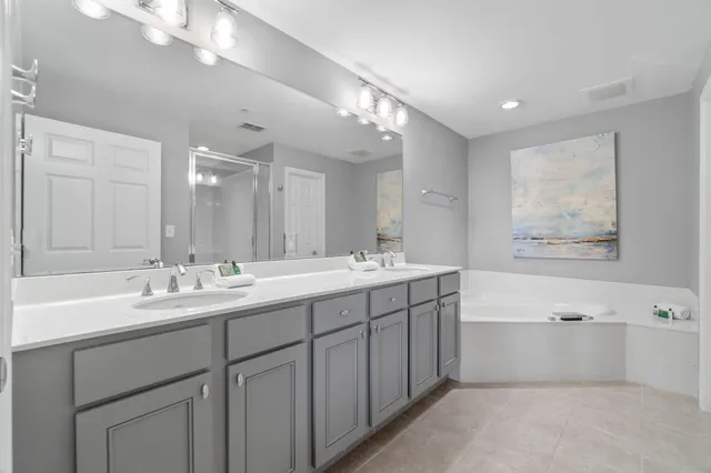 a bathroom with a tub a sink double and mirror