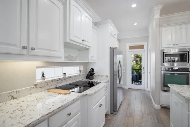 a kitchen with granite countertop white cabinets and a sink