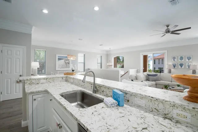 a kitchen with a stove a sink and white cabinets with wooden floor