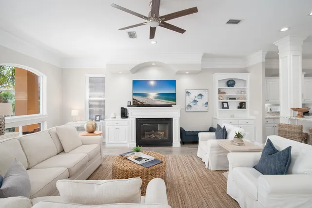 a living room with furniture a fireplace and a chandelier