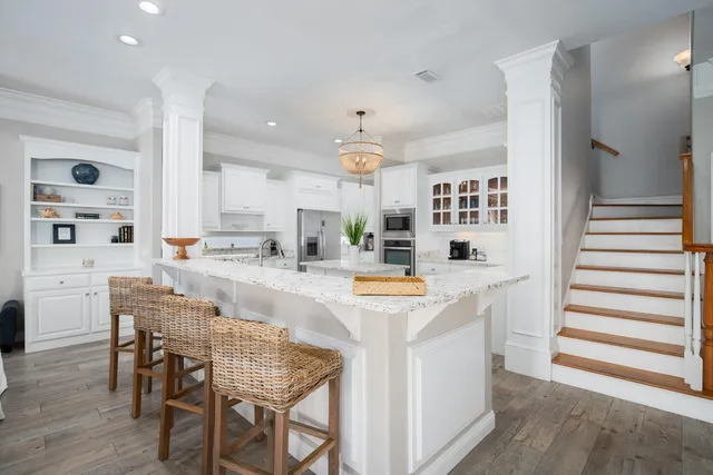 a kitchen with stainless steel appliances kitchen island granite countertop a table chairs and a refrigerator