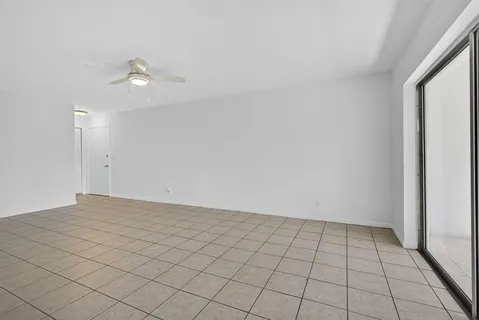 an empty room with white walls and fan