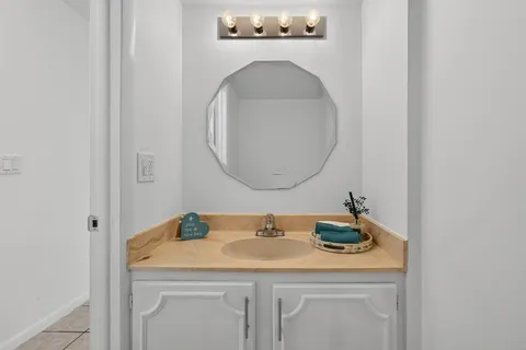 a bathroom with a granite countertop sink and a mirror