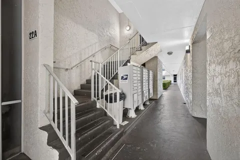 a view of staircase with lots of frames on wall and stairs