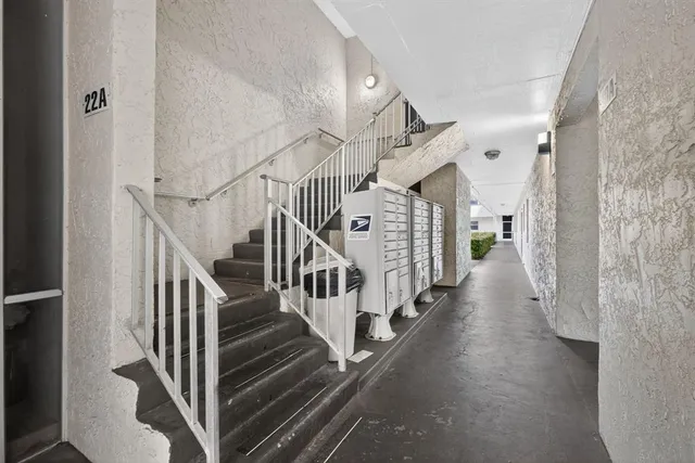 a view of staircase with lots of frames on wall and stairs