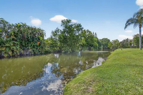 a view of a lake with a yard and potted plants