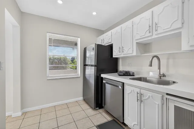 a kitchen with cabinets appliances a sink and a window