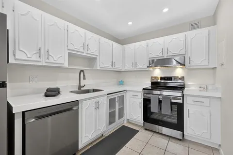a kitchen with cabinets appliances a sink and a counter top