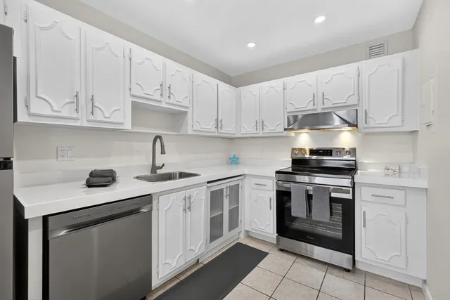 a kitchen with cabinets appliances a sink and a counter top