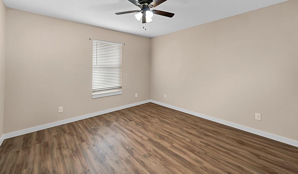210 North Harrison Street McGregor, TX 76657 - Photo 14 of 25 wooden floor in an empty room with a window