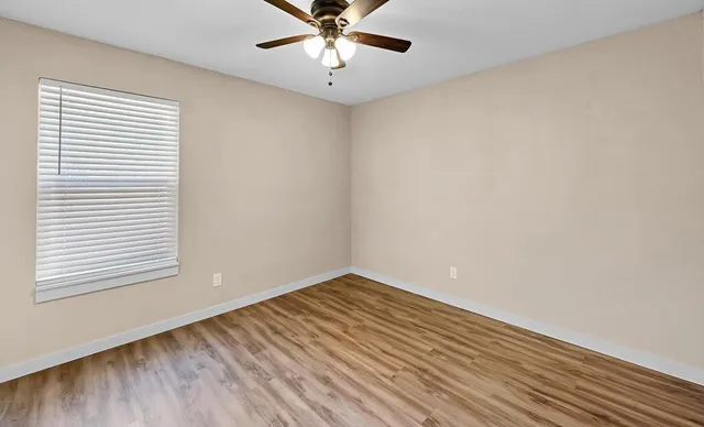 wooden floor in an empty room with a window