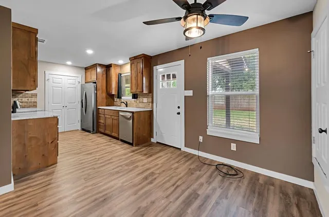 a open kitchen with stainless steel appliances granite countertop a refrigerator oven a sink dishwasher and a stove with wooden floor