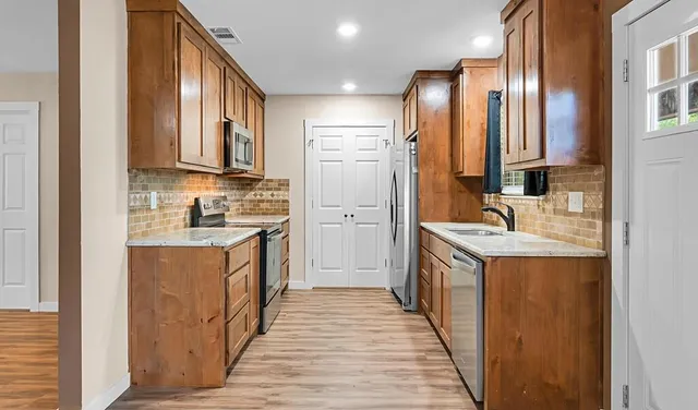 a kitchen with stainless steel appliances granite countertop a sink stove and refrigerator