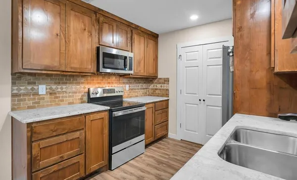 a kitchen with a sink stove and microwave