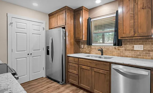 a kitchen with stainless steel appliances granite countertop cabinets and window