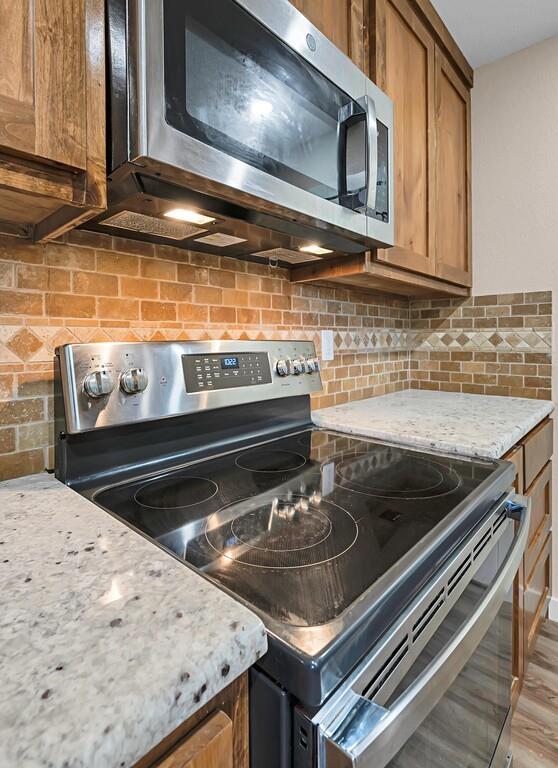 210 North Harrison Street McGregor, TX 76657 - Photo 10 of 25 a kitchen with a stove and a microwave